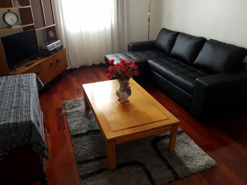 - un salon avec un canapé noir et une table fleurie dans l'établissement Apartment with beautiful ocean and city view, à Funchal