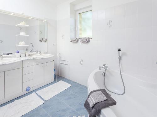 a white bathroom with a tub and a sink at Family Stay in Scenic Cazals in Cazals