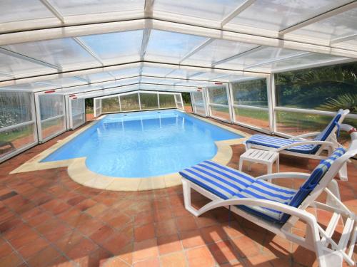 une grande piscine avec deux chaises dans l'établissement Chalet in Plounéour-Trez by Seaside Bay, à Plounéour-Trez