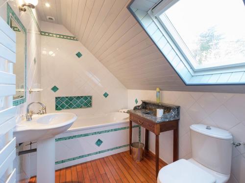 La salle de bains est pourvue de toilettes avec lavabo et d'une lucarne. dans l'établissement Chalet in Plounéour-Trez by Seaside Bay, à Plounéour-Trez