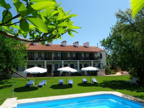 a resort with a swimming pool and a building at Hotel Apartamento Rural Finca La Media Legua in Aracena