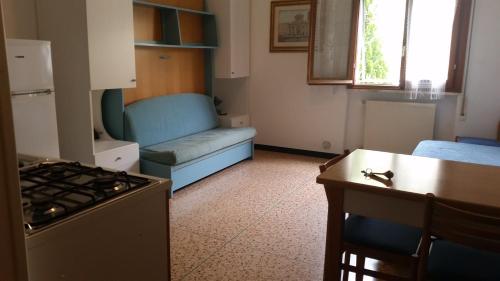 a living room with a couch and a kitchen with a stove at Residence la Vignetta in Varazze