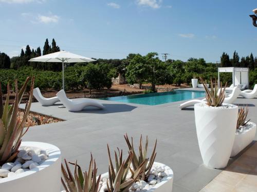 a patio with a pool and some plants and an umbrella at Belvilla by OYO Calet in Muro