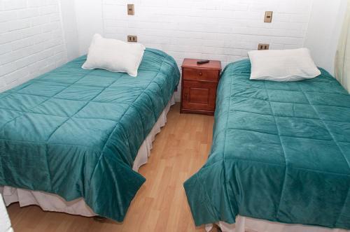 2 Betten nebeneinander in einem Zimmer in der Unterkunft Hotel Altos de Atacama in Copiapó
