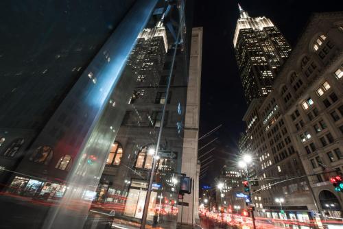a city street at night with tall buildings at U Hotel Fifth Avenue, Empire State Building in New York
