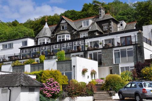 a large stone house with a car parked in front of it at Beech Hill Hotel & Spa in Windermere