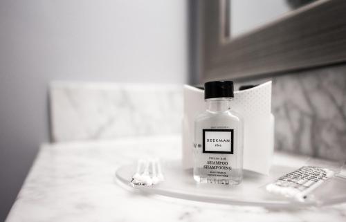 a bottle of alcohol sitting on a bathroom counter at U Hotel Fifth Avenue, Empire State Building in New York