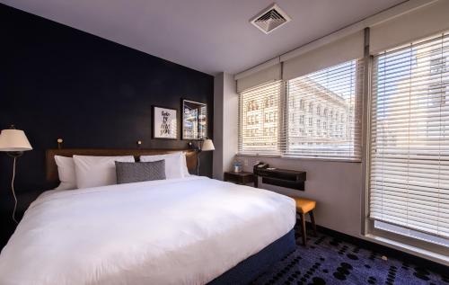 1 dormitorio con 1 cama blanca grande y 2 ventanas en U Hotel Fifth Avenue, Empire State Building, en Nueva York