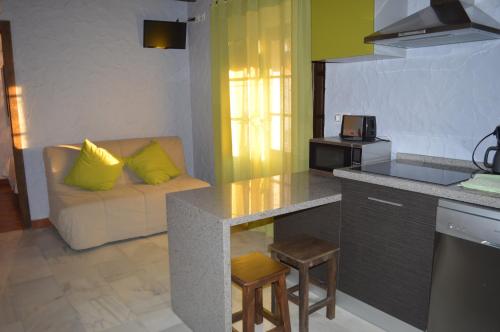 a kitchen and living room with a couch and a table at Casa Mirador San Pedro in Arcos de la Frontera
