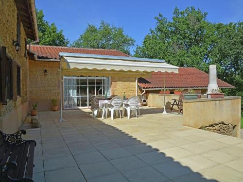 un patio con dosel blanco, mesas y sillas en Traditional villa with pool en Estang