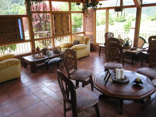 a living room with tables and chairs in a house at Posada La Anjana in Puente Viesgo