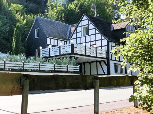 a black and white house with a fence at Pretty holiday home near the ski area in Schmallenberg