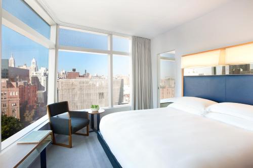 a bedroom with a large bed and a large window at The Standard - East Village in New York