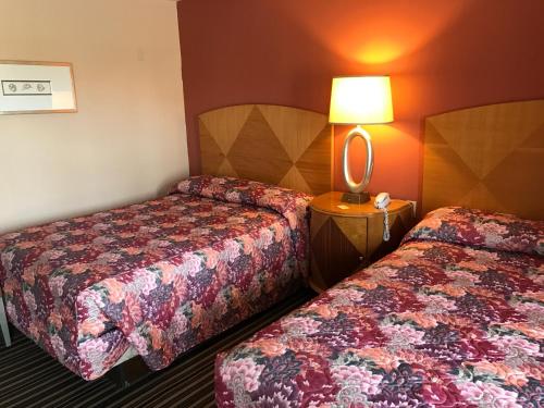 Postel nebo postele na pokoji v ubytování Sunset Motel