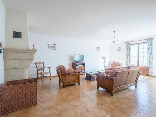uma sala de estar com cadeiras, um sofá e uma televisão em Cosy holiday home in Lantheuil with garden em Villefranche-du-Périgord