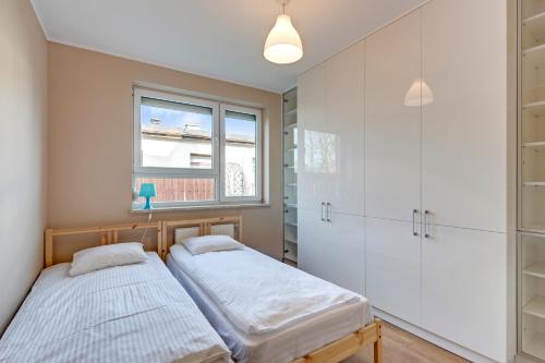 two twin beds in a room with a window at TriApart Villa Nord 3 - Jastrzębia Góra in Jastrzębia Góra