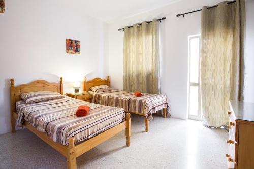 1 dormitorio con 2 camas y toallas naranjas. en Dolphin Court, en Marsalforn