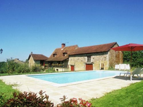 a swimming pool in front of a house with an umbrella at Cozy Holiday Home in Besse with Swimming Pool in Villefranche-du-Périgord