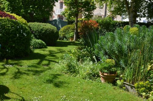 a garden with flowers and plants in a yard at Chambre d'hôtes El Vigot Plaza in Caen