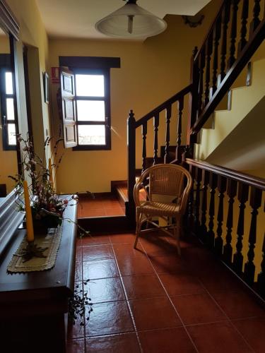 a hallway with a chair and stairs in a house at El Pedroso in Santillana del Mar