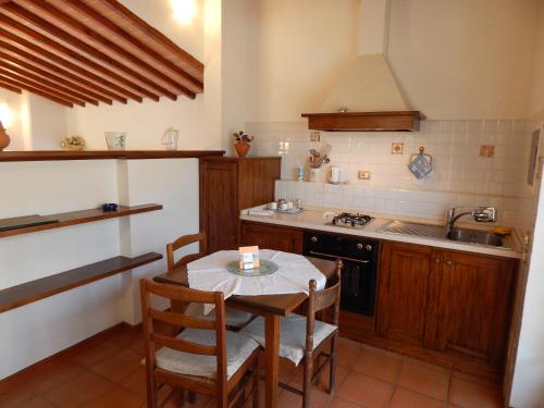 a kitchen with a table and a stove and a sink at Fullino Nero Rta - Residenza Turistico Alberghiera in Siena