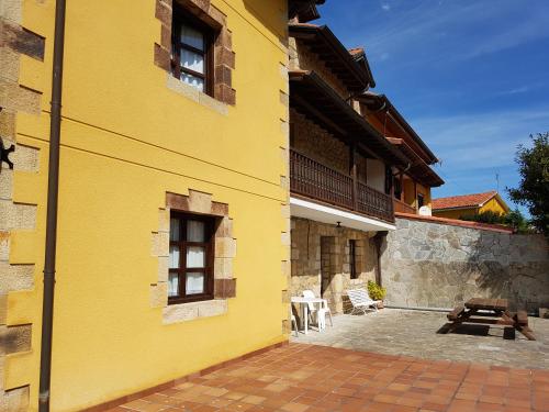 a yellow building with two windows and a patio at El Pedroso in Santillana del Mar