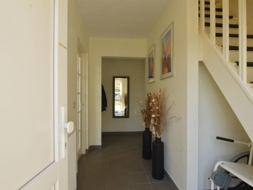 einen Flur eines Hauses mit einer Treppe und Vasen in der Unterkunft Wheelchair friendly house with sauna in Leykaul