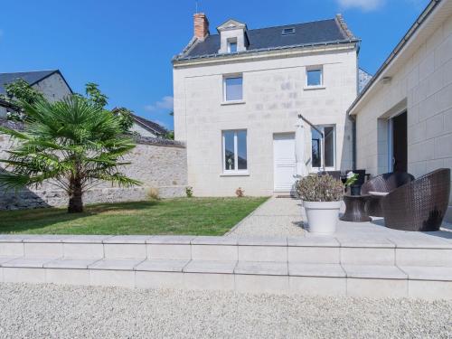 a brick house with a palm tree in front of it at Luxury holiday home with lawn in Beaumont-en-Véron