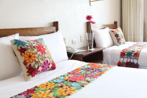 a hotel room with two beds with colorful pillows at La Hacienda Bahia Paracas in Paracas