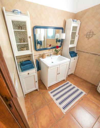 a bathroom with a white sink and a mirror at Finca La Costa in Tinajo