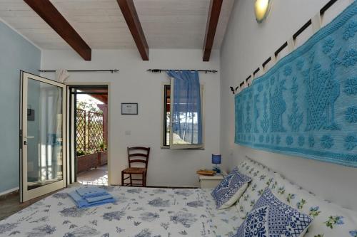 a bedroom with a bed with a blue and white bedspread at B&B Nonno Stacca in Stintino