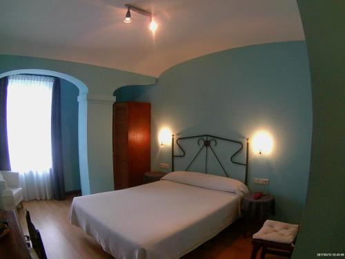 a bedroom with a white bed and blue walls at Hotel Los Laureles in Luanco