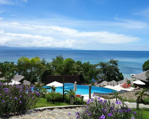 a view of a swimming pool with the ocean in the background at Bunaken Oasis Dive Resort and Spa in Bunaken