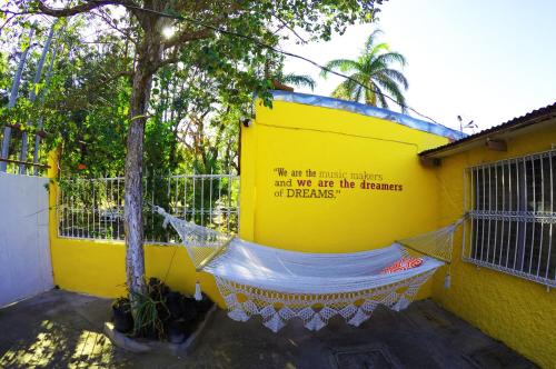 a yellow building with a hammock in front of it at Casa Lucia in Managua