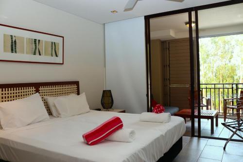 a bedroom with a bed with a red pillow on it at 422 Temple Beachside Penthouse in Palm Cove