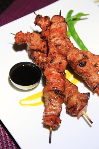 a white plate of food with skewers of food at Star View Boutique Resort in Dumaguete