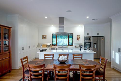 una cucina con tavolo, sedie e isola cucina di Brockenchack Vineyard Bed & Breakfast a Mount McKenzie