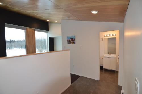 Zimmer mit einem Flur mit Waschbecken und Spiegel in der Unterkunft Boreale Ranch in Carcross