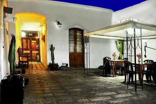 a patio with a table and chairs and an umbrella at La Compañía de Jerusalen in Arequipa