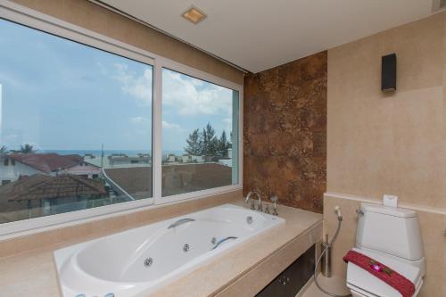 The Palms, Kamala Beach - SHA Extra Plus في شاطئ كامالا: حمام مع حوض ومرحاض ونافذة