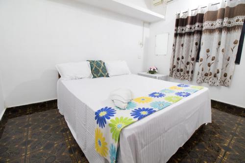 a bedroom with a bed with a colorful blanket on it at Brittos Homestay in Mandrem