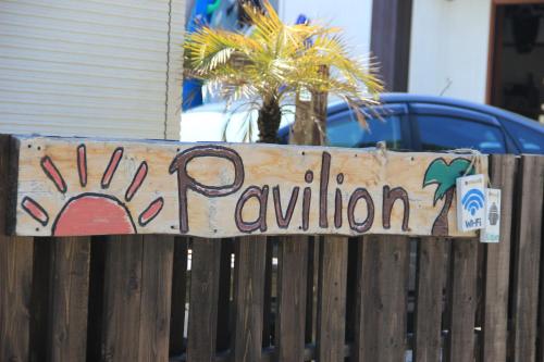 a sign on a wooden fence with the word reunion at PavilionSurf&Lodge in Shishikui