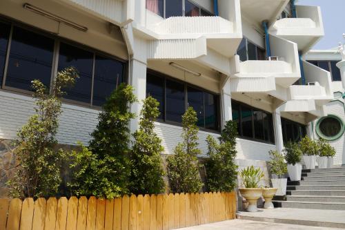 a building with a fence in front of it at Lertnimit Hotel in Chaiyaphum