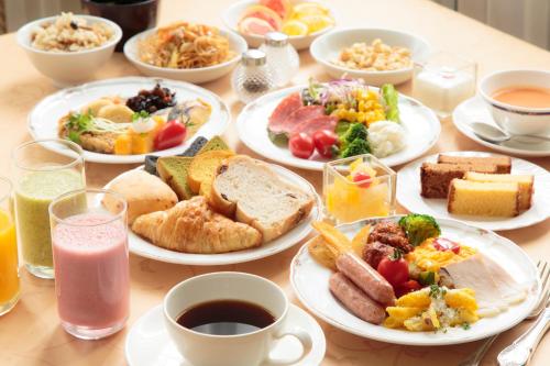 a table topped with plates of breakfast foods and drinks at Hotel Monterey Nagasaki in Nagasaki