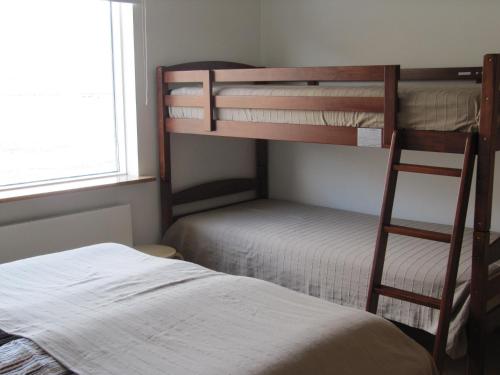 a bedroom with two bunk beds and a bed at Seydisfjördur Guesthouse in Seyðisfjörður