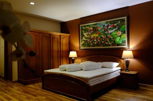 1 dormitorio con 1 cama con una pintura en la pared en Villa Forest Hill B6, en Bandung