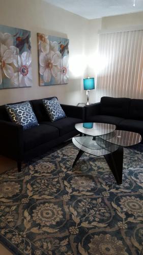 a living room with a black couch and a table at Beautiful 2 bedroom 1 bath in Tamuning