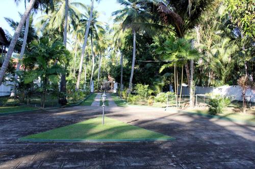 a golf course in the middle of a road with palm trees at Fortune Rest Villa in Marawila