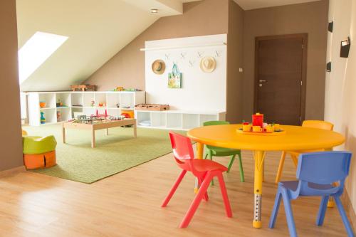 a room with a yellow table and colorful chairs at Penzión Tri Koruny in Spišská Stará Ves