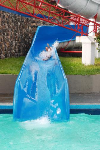 a person riding a water slide in a pool at Hotel y Parque Acuatico Agua Sol Alegria in Honda